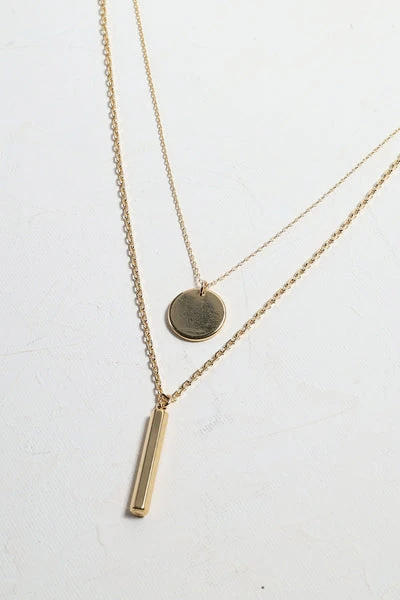 Gold pendant necklace on a light textured background